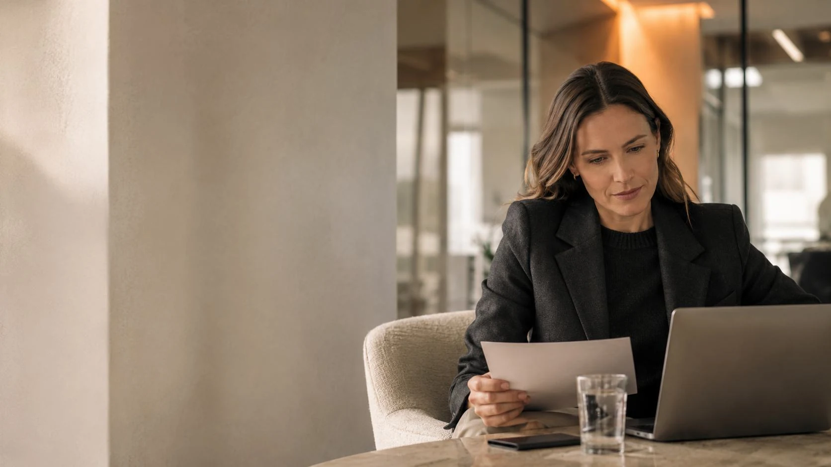 DigiDoe team member reviewing a client document at a laptop in a warm office