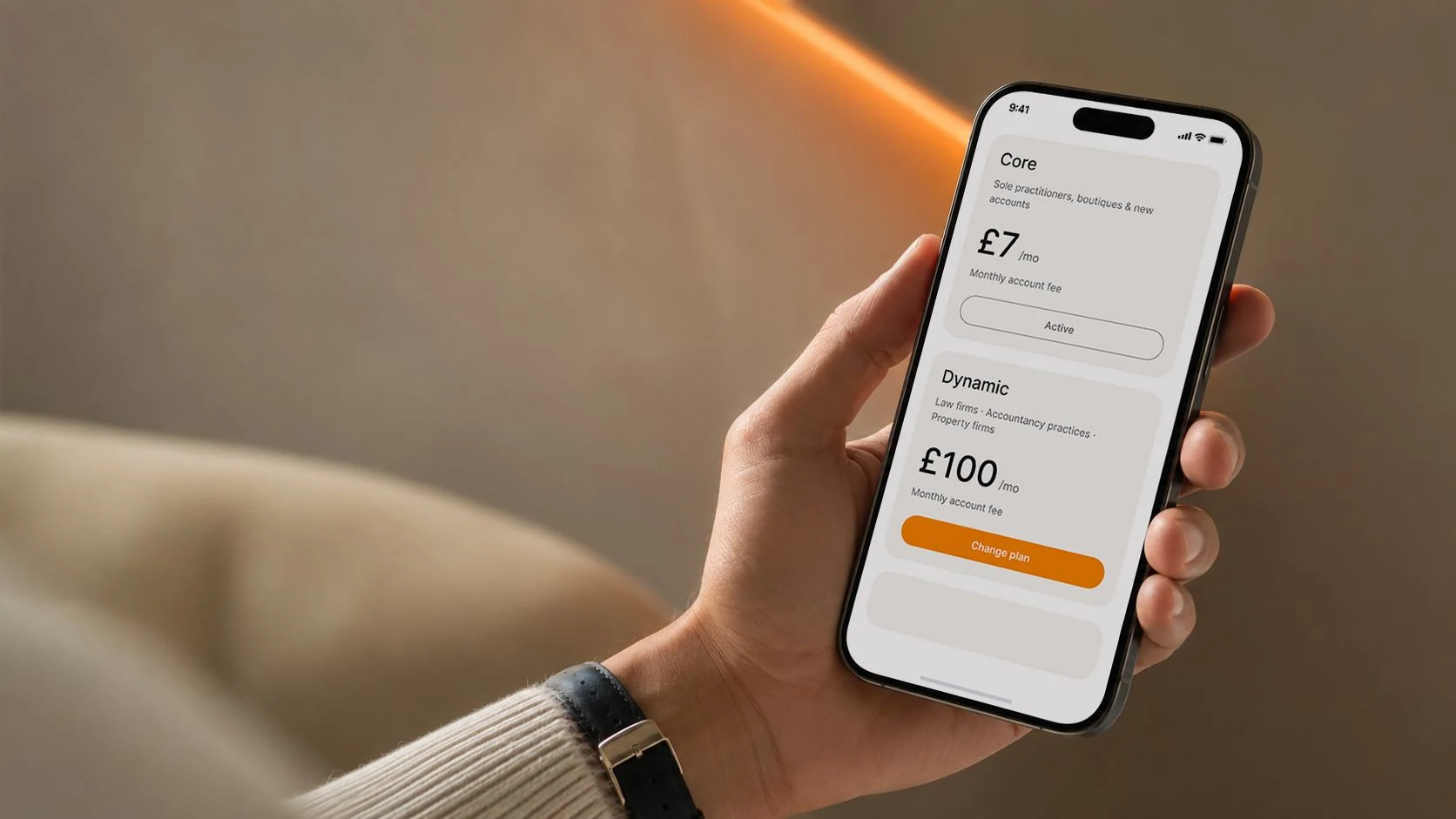 Hand holding a phone with DigiDoe plans on screen: Core active at £7 a month, Dynamic at £100 a month with a change-plan button